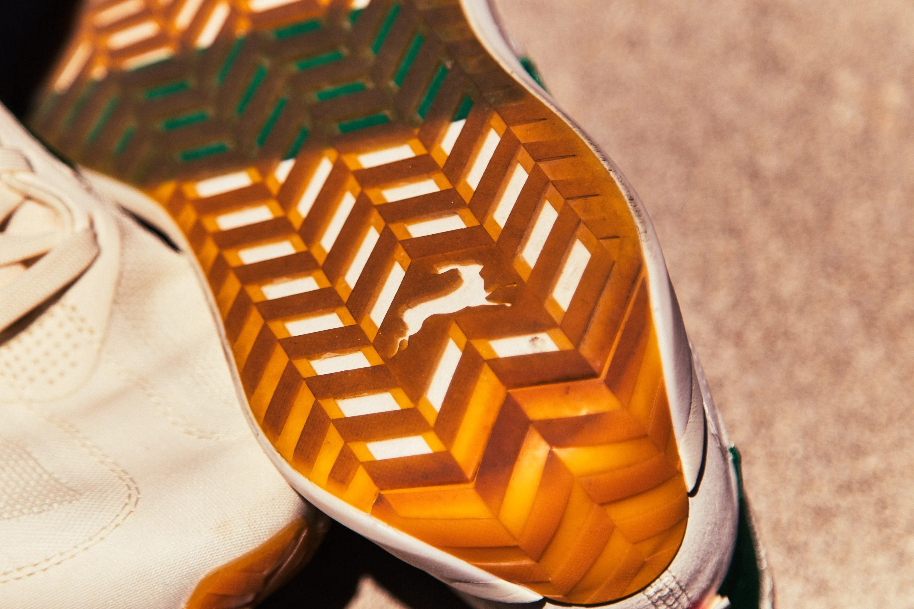 Detailed view of the sole of a sneaker featuring a geometric pattern and a logo.