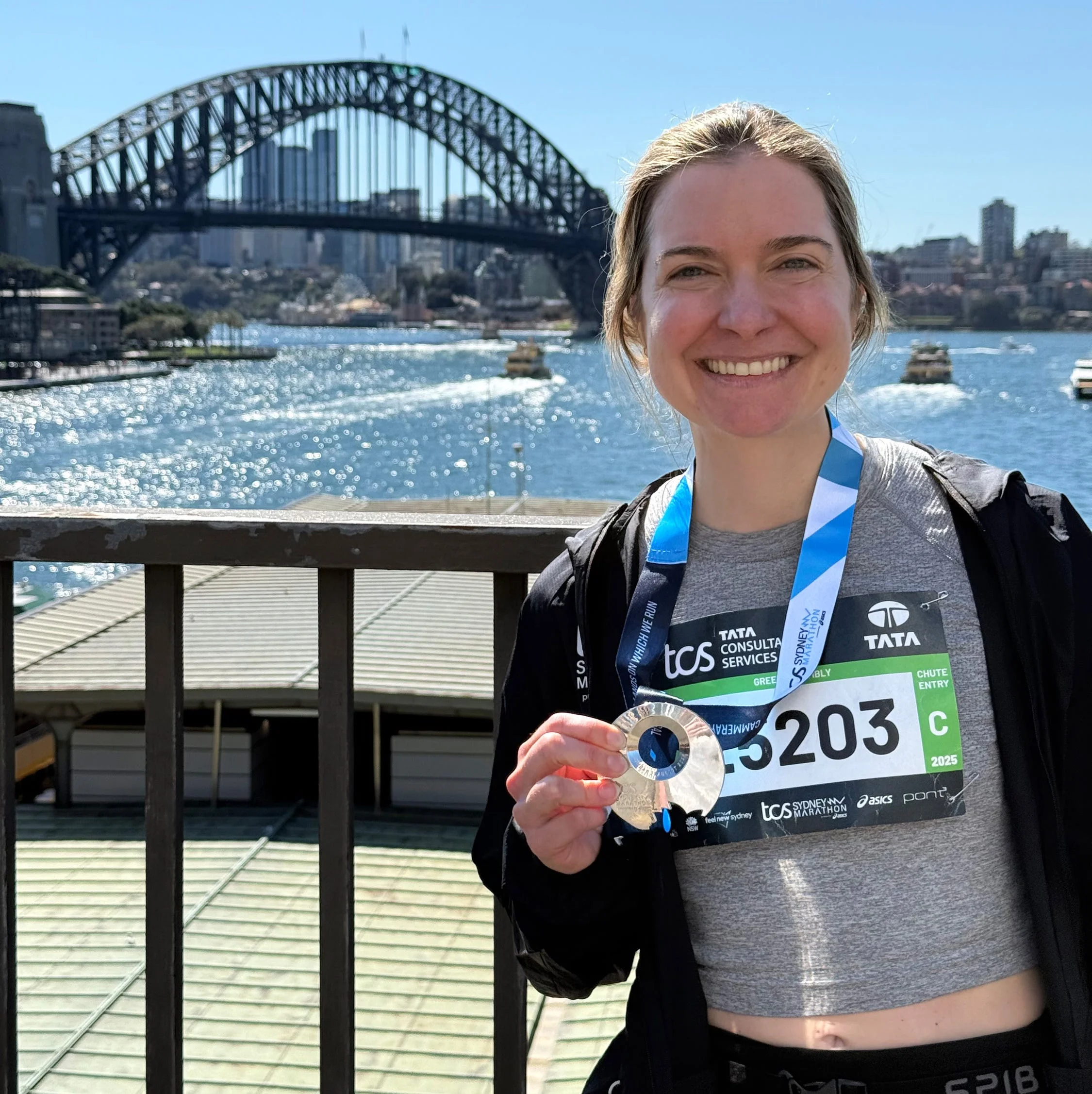 a runner posing for a photo holding up their medal