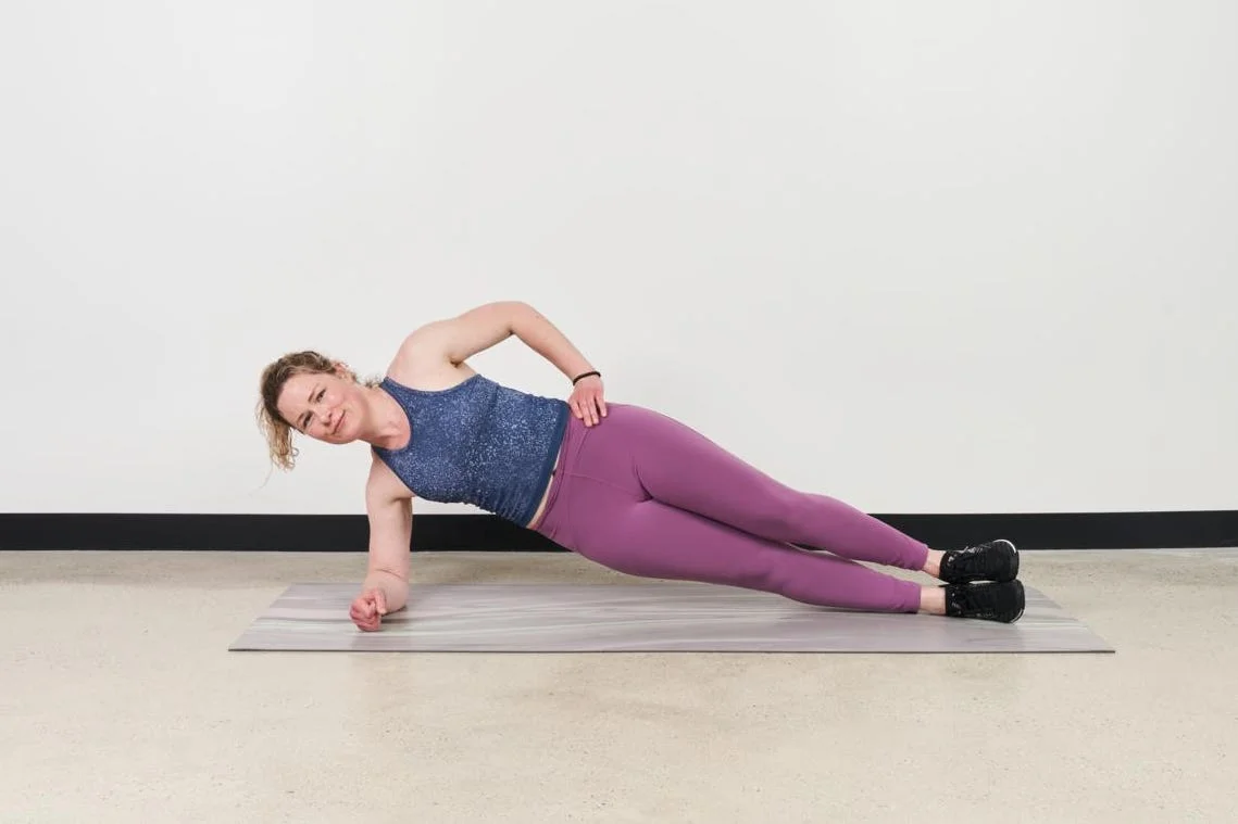 demonstration of a side plank exercise on a mat