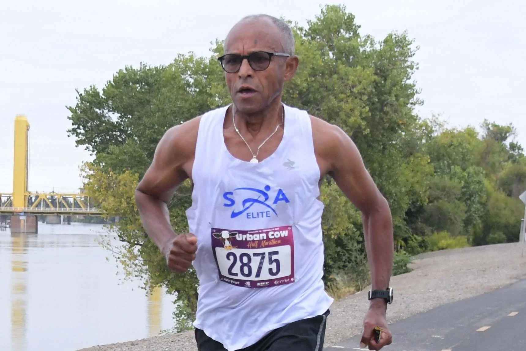 Runner in athletic gear competing in a half marathon along a scenic path by the water. Runner in athletic gear competing in a half marathon along a scenic path by the water.