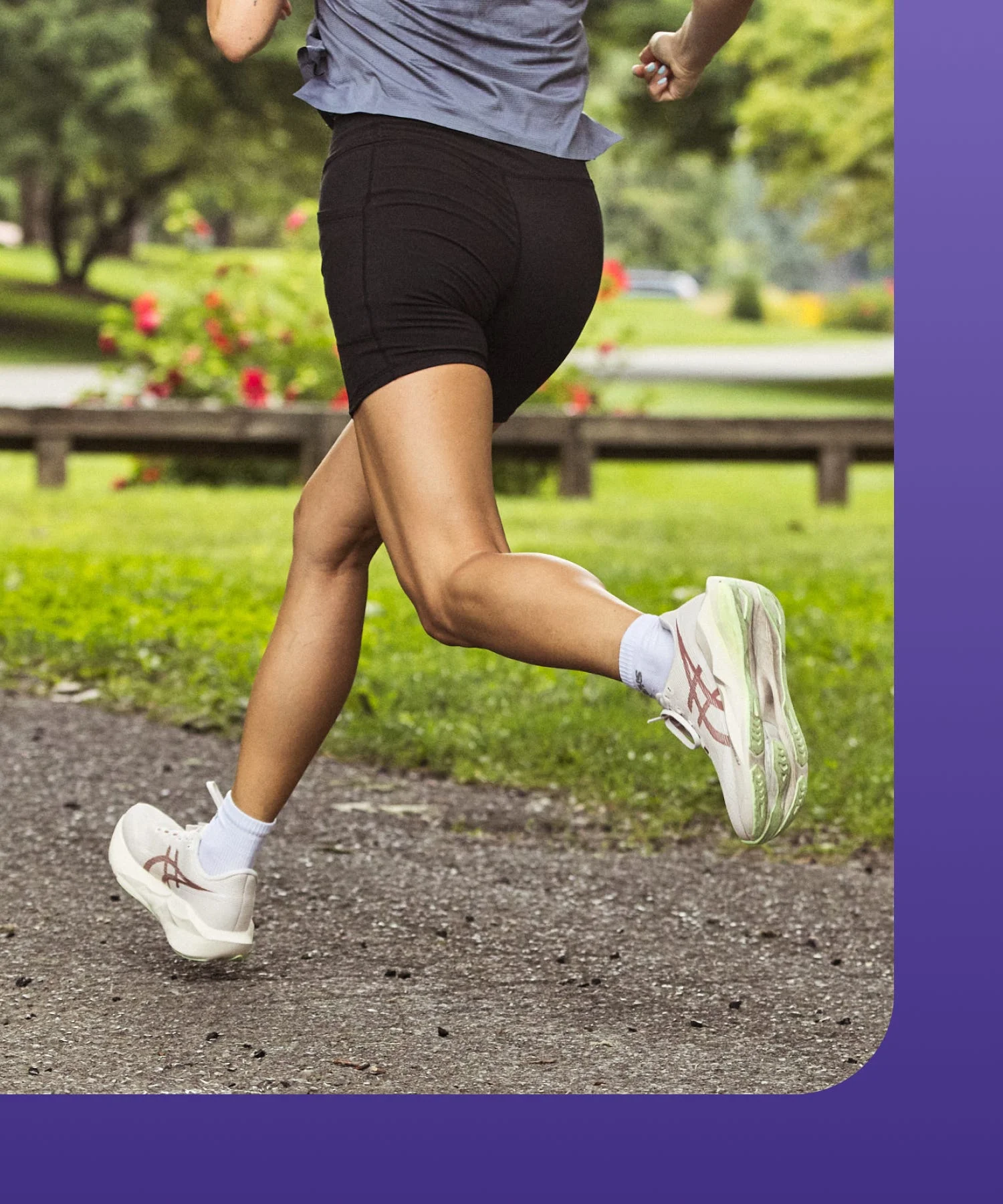 Person running in a park, wearing athletic shorts and sneakers.