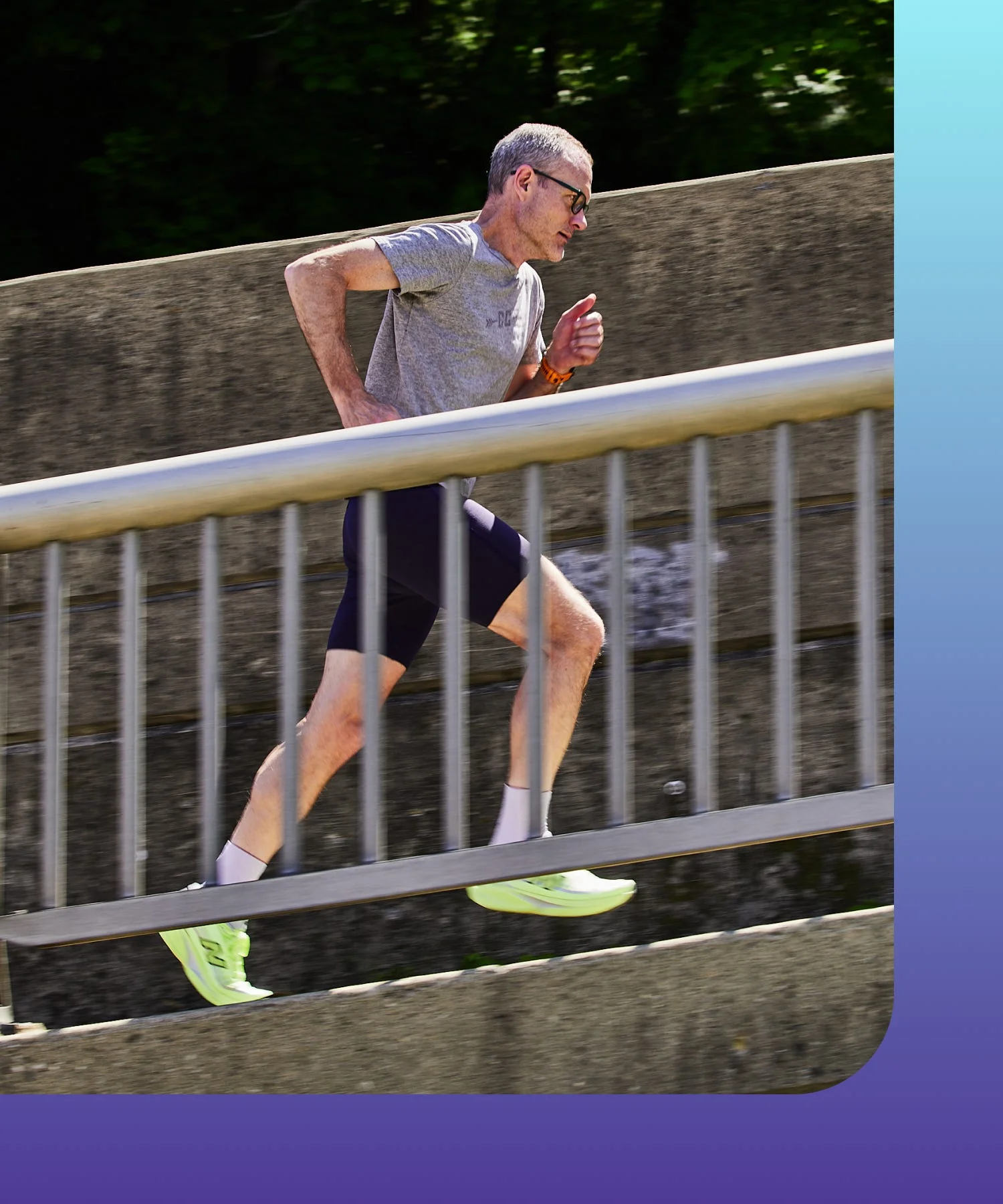 Runner in motion on a path beside a railing.