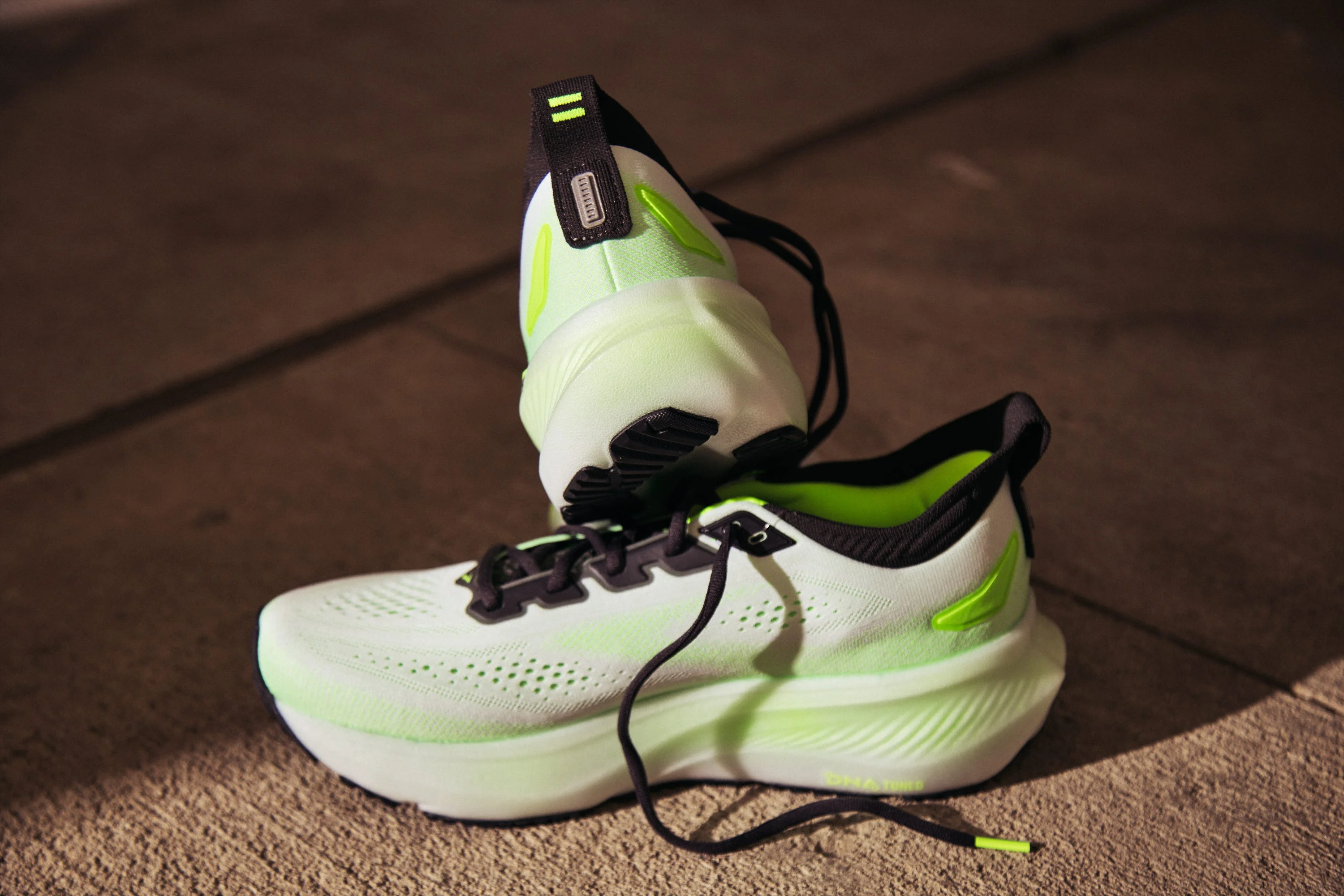 Pair of neon green and black running shoes on concrete surface Pair of neon green and black running shoes on concrete surface