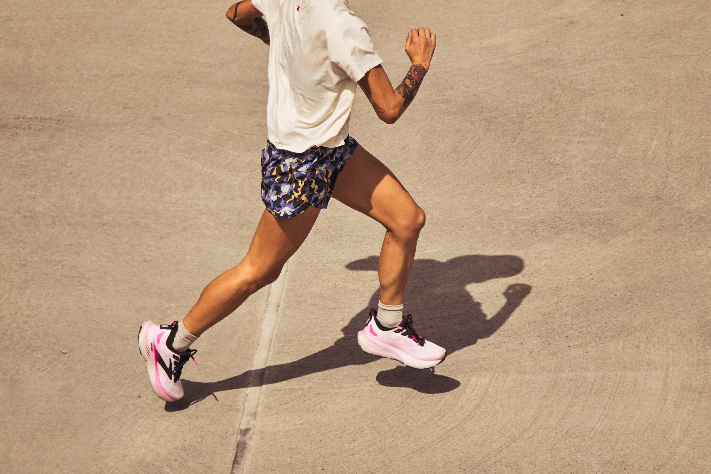 Person running outdoors in colorful shorts and pink sneakers. Person running outdoors in colorful shorts and pink sneakers.