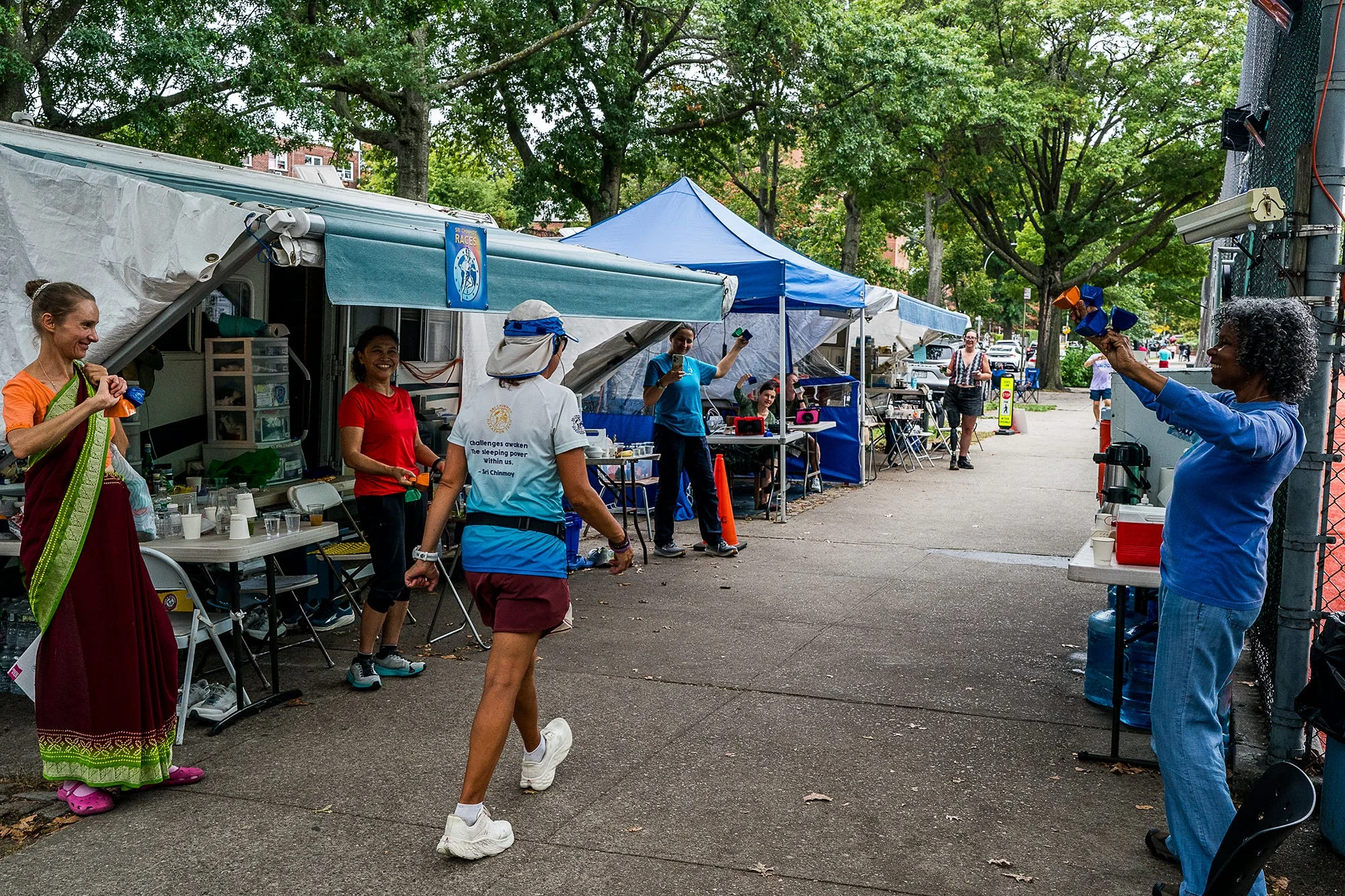 RWD supports ring bells for runners marking the halfway point of the race during the sri chinmoy 3100 mile race in queens, new york on september 24, 2025 the race circles a high school over the corse of 2 months for 3100 miles
